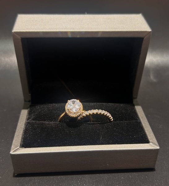 Bague solitaire et alliance sertie dans un écrin gris